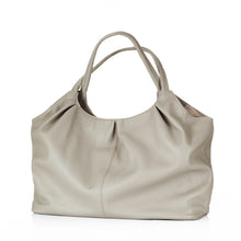 Lade das Bild in den Galerie-Viewer, Der Shopper „San José“ ist ein wahres Platzwunder in zeitlos schönem Design. Gefertigt ist die Tasche aus herrlich griffigem Rindsleder in Beige. Auch das Innenfutter ist in Beige gehalten. Als Verschlussart dient ein Druckknopf. Dank ihrer geräumigen Abmessungen bietet diese schöne Tasche ausreichend Platz und kann sogar als Weekender zum Einsatz kommen. Getragen werden kann sie in der Hand, in der Ellenbeuge oder über der Schulter.